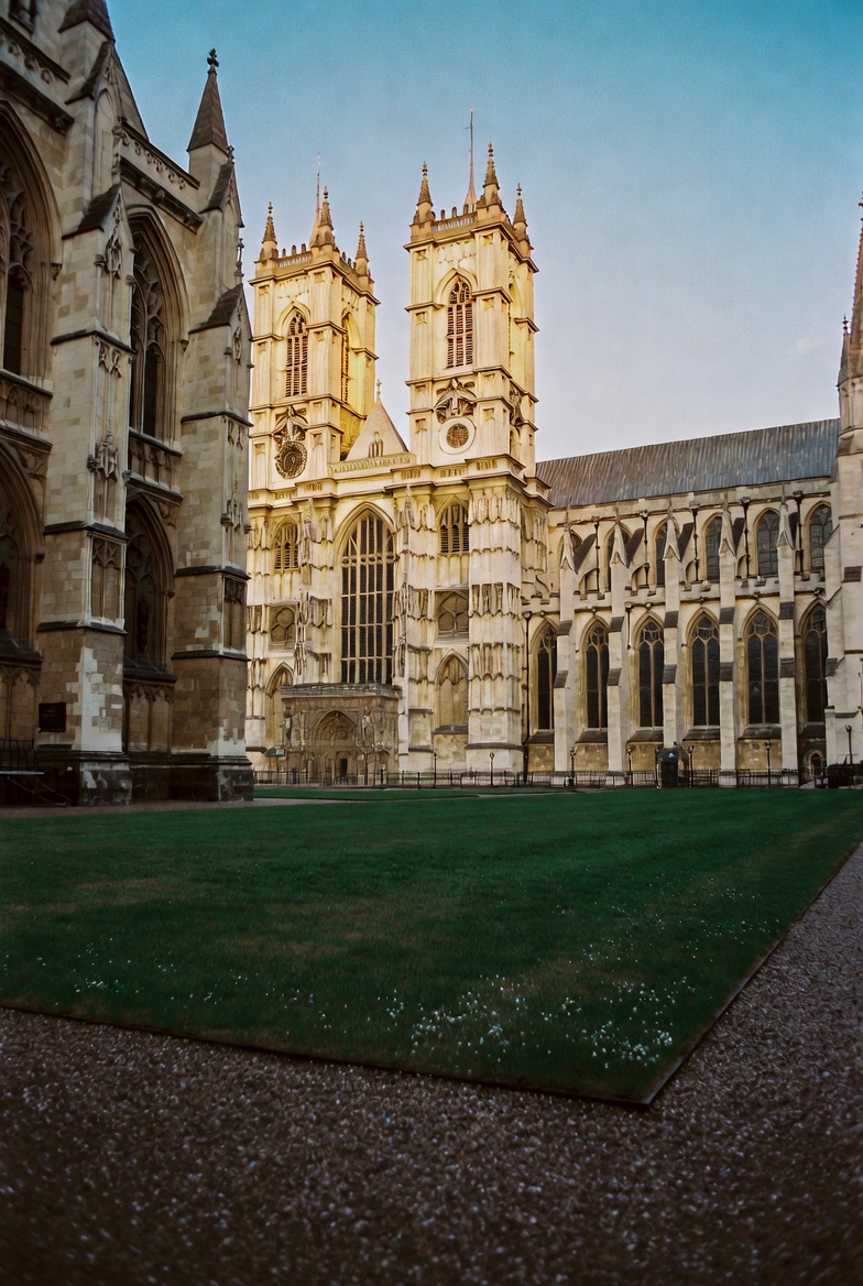 The west towers of Westminster Abbey rising above its green at first light.